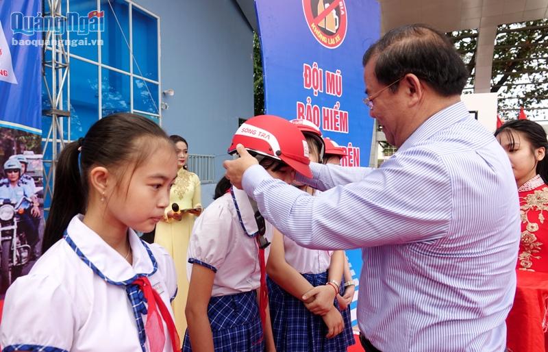 Phó Chủ tịch Thường trực UBND tỉnh Nguyễn Tăng Bính trao tặng mũ bảo hiểm cho các em học sinh