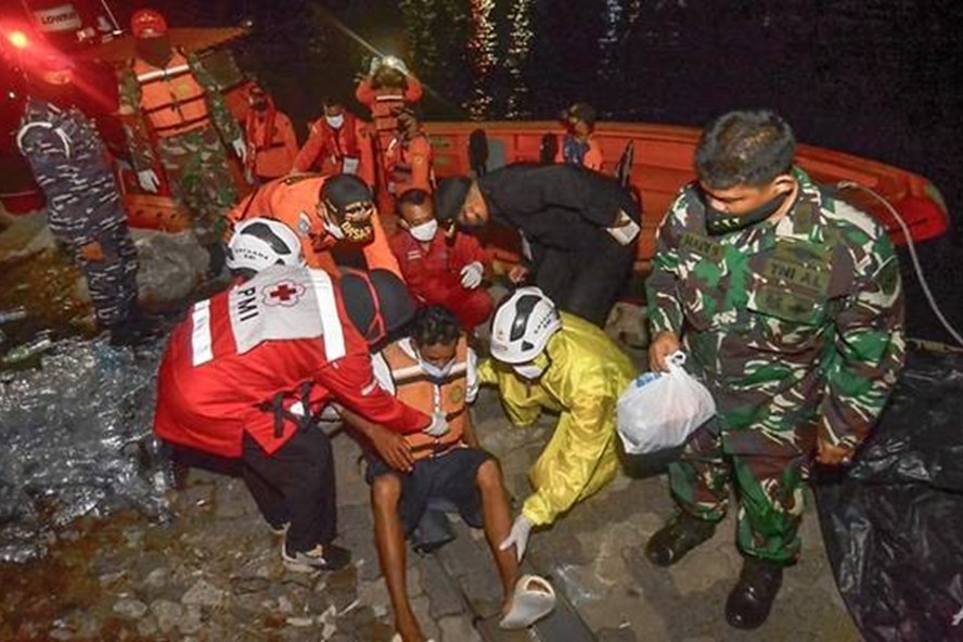 Các thành viên đội cứu hộ đã đang di chuyển một người sống sót trên chiếc thuyền bị lật chở 16 người ở eo biển Sunda gần Anak Krakatau, Indonesia hôm 20.6. Ảnh: AFP.