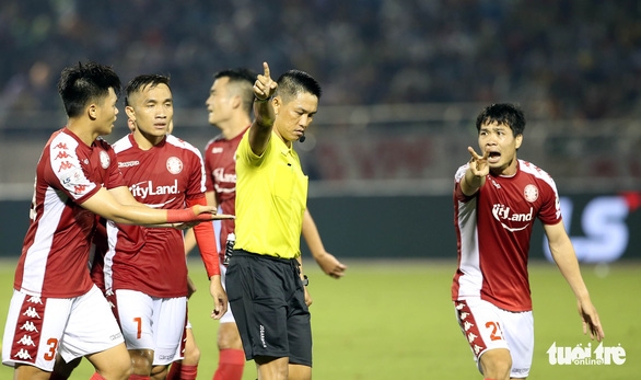 Công Phượng (phải) phản ứng mạnh với trọng tài chính Trần Văn Trọng ở tình huống Thành Chung (Hà Nội FC) lần thứ hai để bóng chạm tay trong vòng cấm - Ảnh: QUANG ĐỊNH.