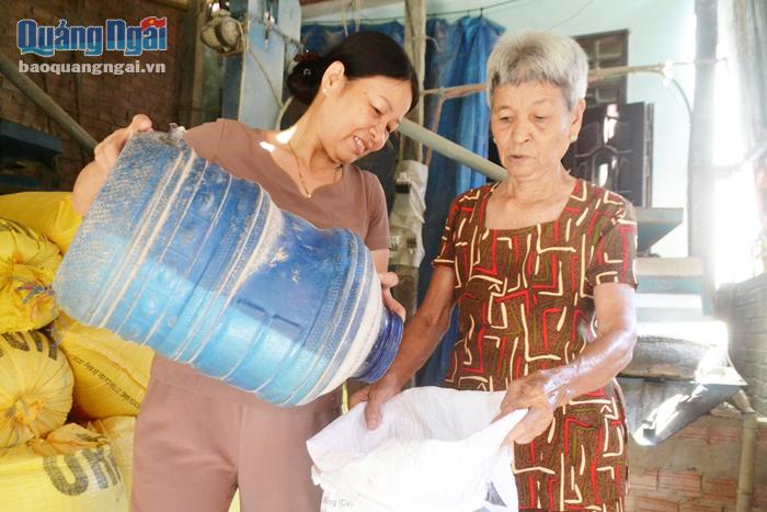 Bà Nguyễn Thị Thanh Vân (bên trái) thu gom gạo từ hũ gạo tình thương bán gây quỹ.
