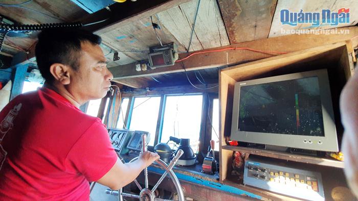 Trong hải trình đánh bắt, thuyền trưởng Lê Tấn Công vừa lái tàu vừa nhìn vào máy dò để tìm đàn cá. 