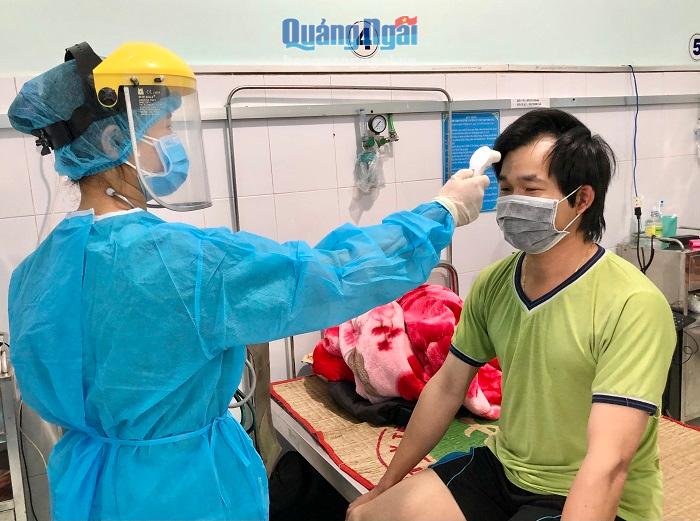 Kiểm tra thân nhiệt một trường hợp cách ly tại cơ sở 2 Trung tâm Y tế huyện Bình Sơn