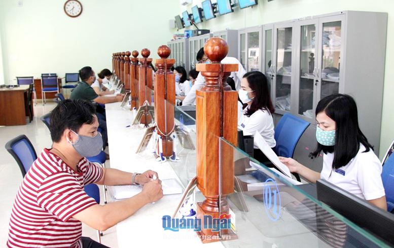 Công chức bộ phận một cửa UBND thị trấn Châu Ổ (Bình Sơn) giải quyết thủ tục hành chính cho công dân. 