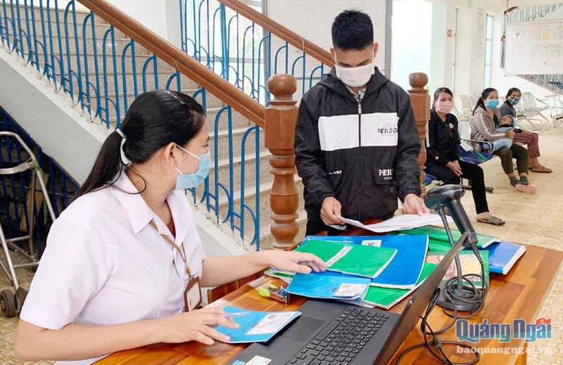 Cán bộ Trung tâm Y tế huyện Ba Tơ giải quyết thủ tục BHYT cho bệnh nhân.     Ảnh: A.NGUYỆT