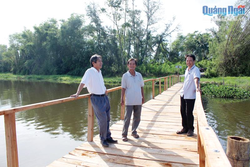 Ông Đỗ Quốc Khánh (đứng giữa) hạnh phúc khi hoàn thành cây cầu mơ ước, giúp nông dân thuận tiện trong sản xuất nông nghiệp. 