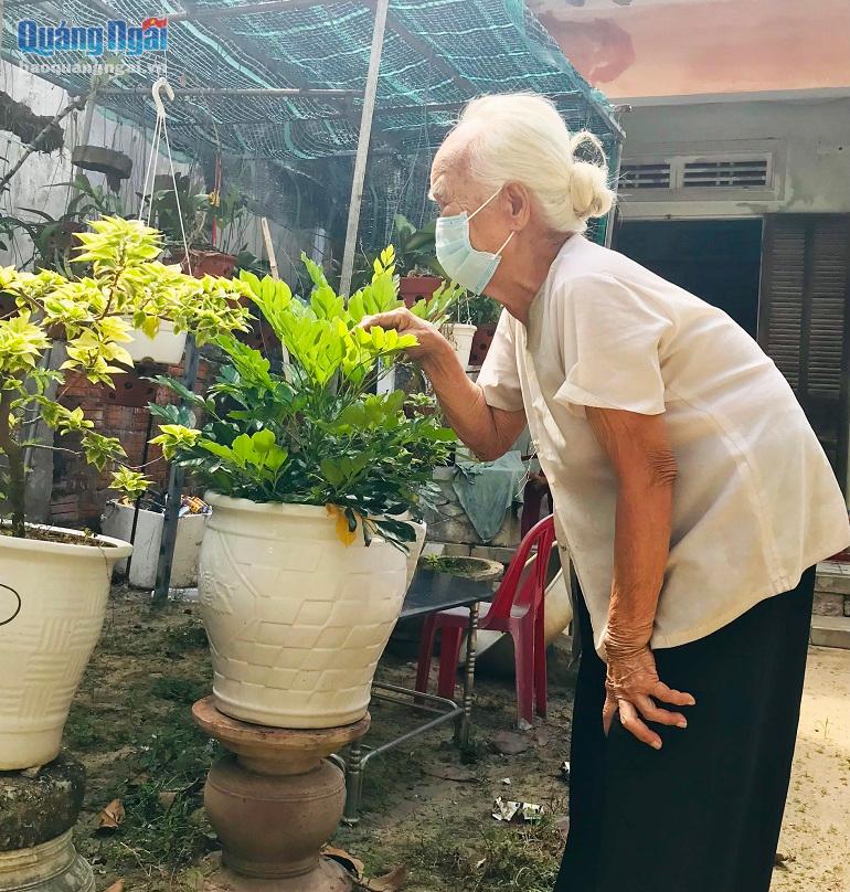Bà Lê Thị Để chăm sóc vườn hoa trong nhà  ẢNH: CD