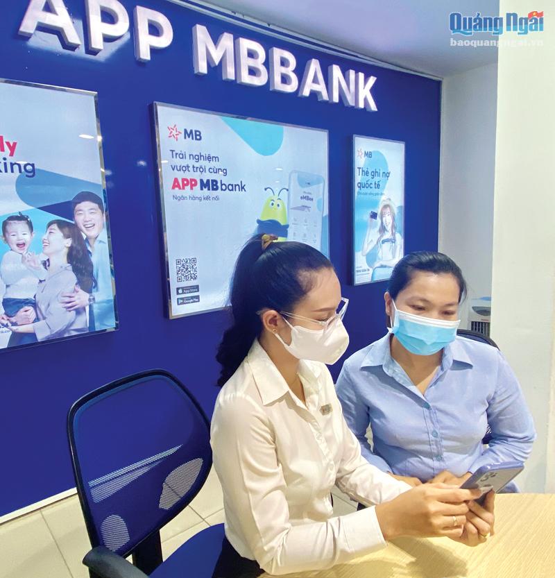 Nhân viên MB Quảng Ngãi hướng dẫn khách hàng cài đặt và nộp thuế điện tử qua ứng dụng của ngân hàng.