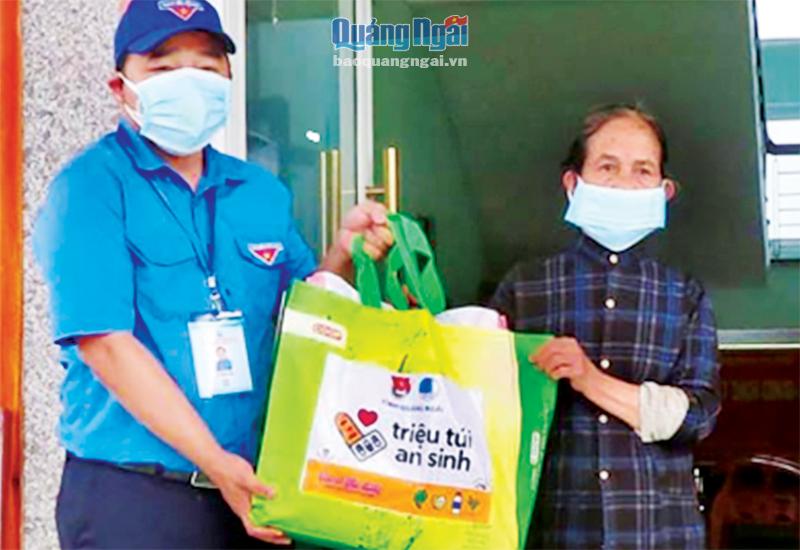  Phó Bí thư Tỉnh đoàn Lê Văn Vin tặng quà cho người dân thị trấn Trà Xuân (Trà Bồng).                                       ẢNH: PV