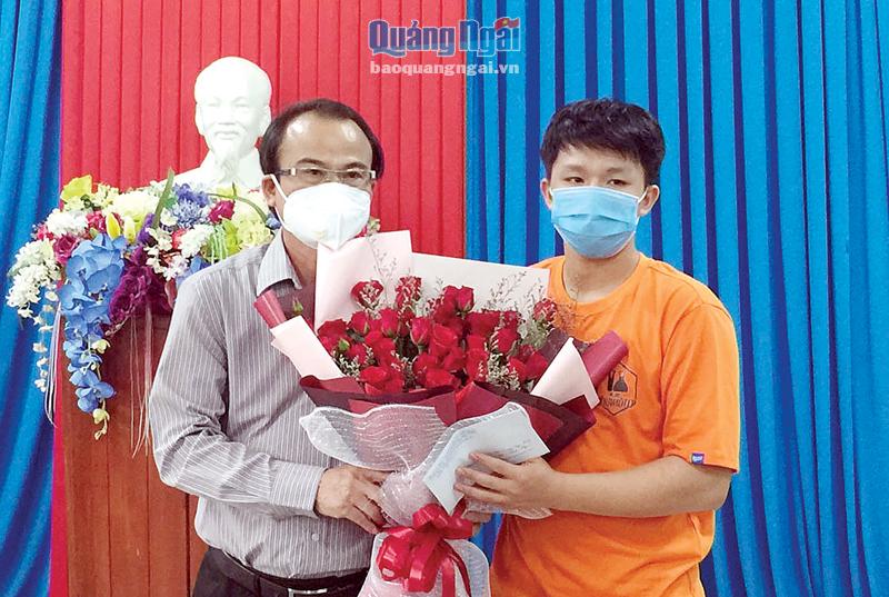 Giám đốc Sở GD&ĐT Nguyễn Ngọc Thái tặng hoa và quà động viên em Trương Công Minh.     Ảnh: TR.PHƯƠNG