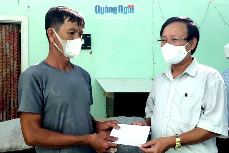   Bí thư Huyện ủy Bình Sơn Lương Kim Sơn tra quà cho gia đình anh Nguyễn Nhân, có nhà bị tốc mái hoàn toàn. 