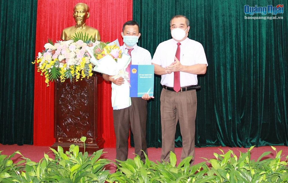 Phó Chủ tịch Thường trực UBND tỉnh Trần Hoàng Tuấn trao Quyết định và tặng hoa chúc mừng ông Nguyễn Phước Bình.