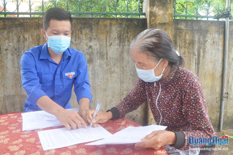 Đoàn viên, thanh niên xã Tịnh Khê (TP.Quảng Ngãi) hướng dẫn người dân khai thông tin trước khi tiêm vắc xin.