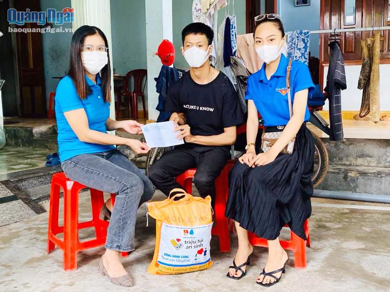 Chị Trần Thị Hoài Hiền (bên trái) tặng quà cho thanh niên khuyết tật ở TP.Quảng Ngãi.  