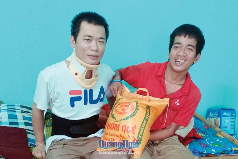 Anh Quảng Đình Hậu (bên phải) trao gạo hỗ trợ anh Võ Văn Vũ, ở xã Tịnh Khê (TP.Quảng Ngãi).                 Ảnh: UYÊN ANH 