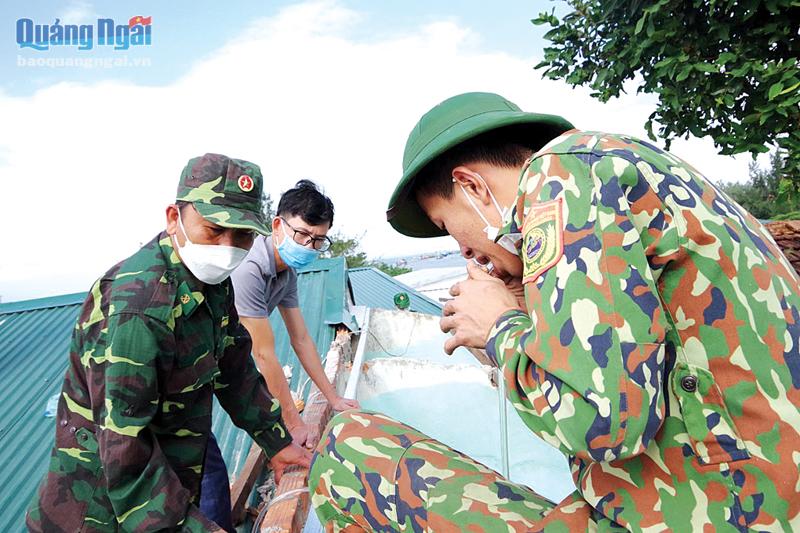 Cán bộ, chiến sĩ Đồn Biên phòng cửa khẩu Cảng Dung Quất sửa chữa lại nhà cho cụ Nguyễn Thị Rỡ, ở xã Bình Thuận (Bình Sơn).