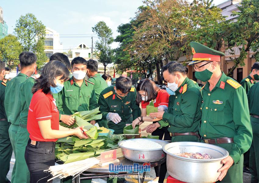 Cán bộ, chiến sĩ lực lượng vũ trang tỉnh gói bánh chưng tặng đồng bào nghèo nhân dịp Tết. Ảnh: Huỳnh Huy