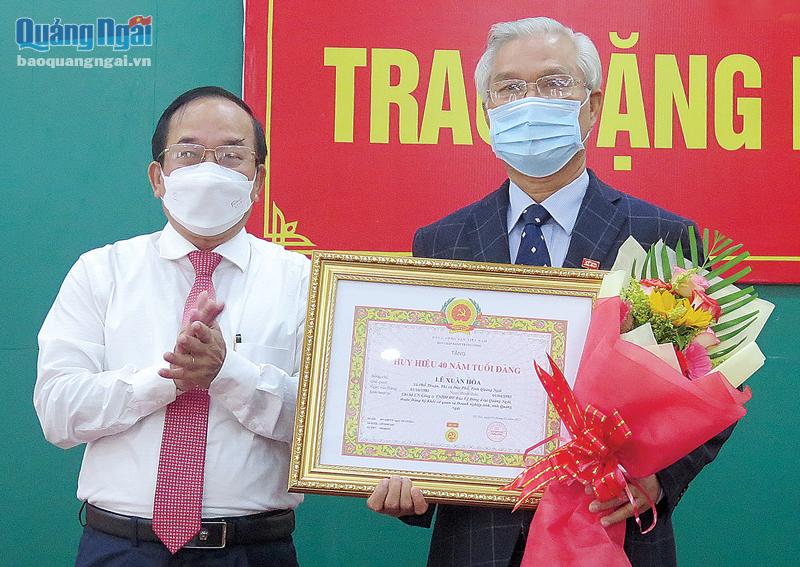 Bí thư Đảng ủy Khối Cơ quan và Doanh nghiệp tỉnh Nguyễn Thanh (bên trái) trao Huy hiệu 40 năm tuổi Đảng cho đảng viên Lê Xuân Hòa.
