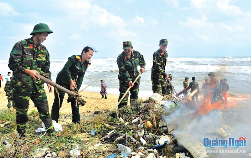 Thượng úy Trần Chí Hồng (đầu tiên bên trái) cùng đồng đội xử lý rác thải, bảo vệ môi trường biển. 