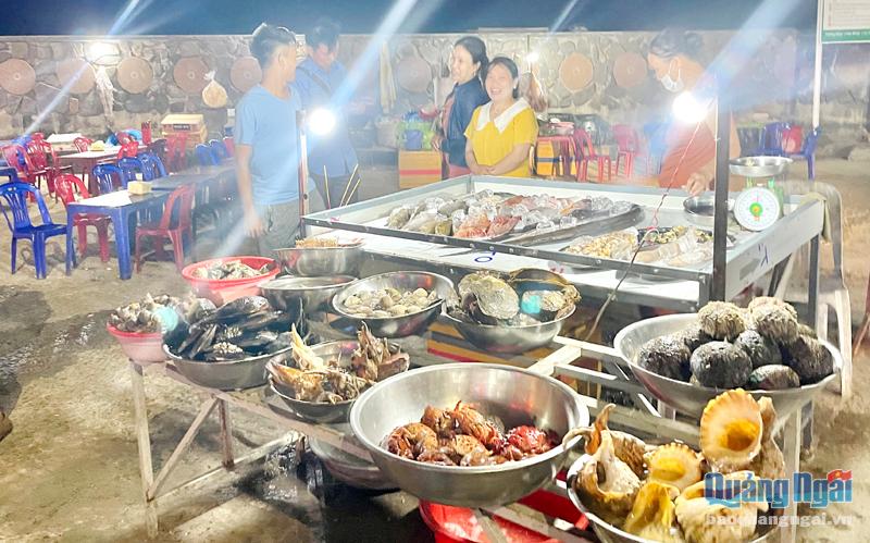 Khách du lịch tham quan, tìm mua hải sản ở đảo Lý Sơn.