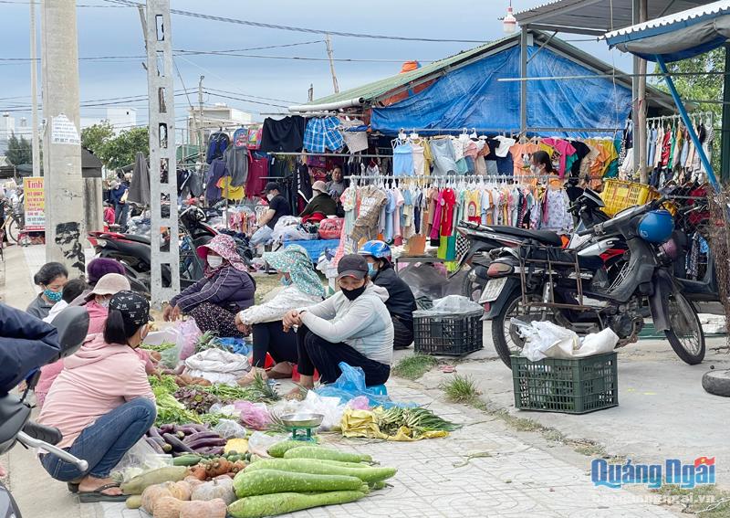 Người dân xã Nghĩa An (TP.Quảng Ngãi) mua bán tại chợ tạm gần cầu An Phú, sát sông Phú Thọ.                                Ảnh: THANH HUYỀN