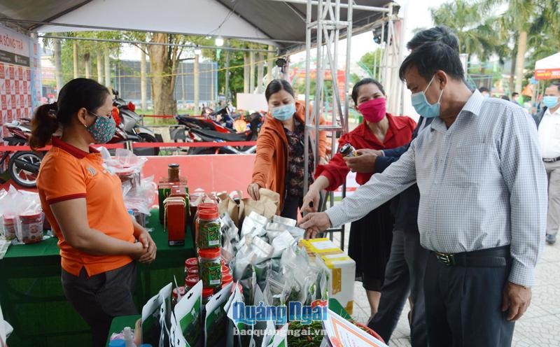 Người dân tham quan, mua sắm tại phiên chợ hàng Việt được tổ chức ở huyện Minh Long vào tháng 4/2022. ẢNH: NG.VIÊN