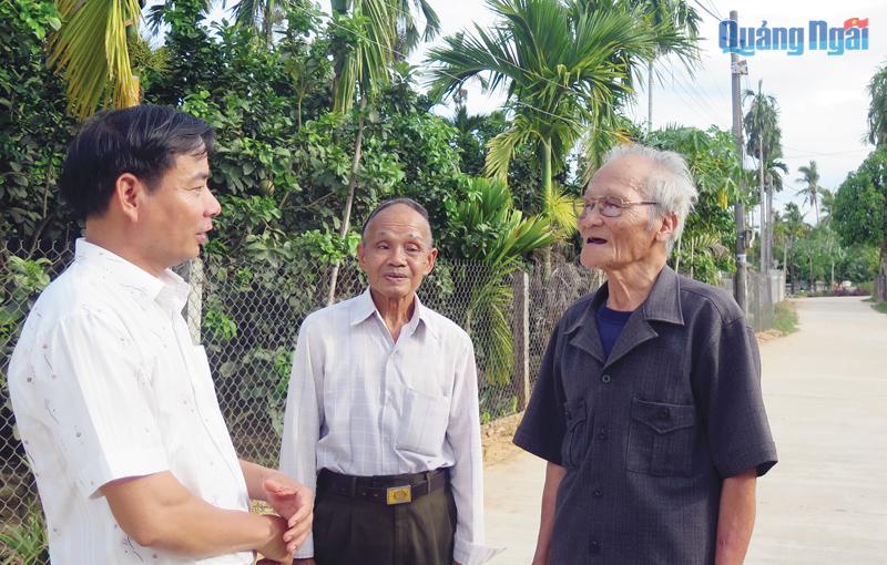 Bí thư Đảng ủy thị trấn Chợ Chùa (Nghĩa Hành) Võ Văn Vạn (bên trái) gặp gỡ đảng viên lớn tuổi để nắm bắt tình hình ở địa phương.