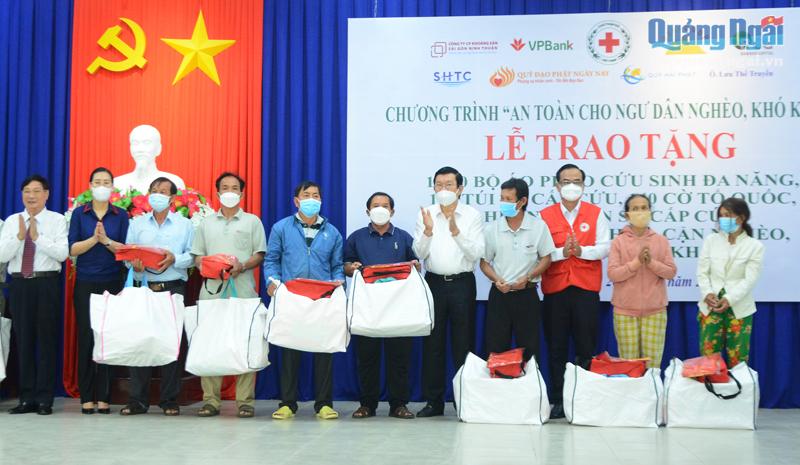 Nguyên Chủ tịch nước Trương Tấn Sang và lãnh đạo tỉnh tặng áo phao cho ngư dân nghèo Quảng Ngãi.  Ảnh: ÁI KIỀU