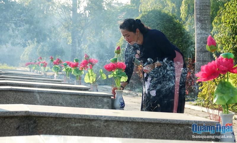 Phó Bí thư Tỉnh ủy Đinh Thị Hồng Minh dâng hương lên các phần mộ liệt sĩ.