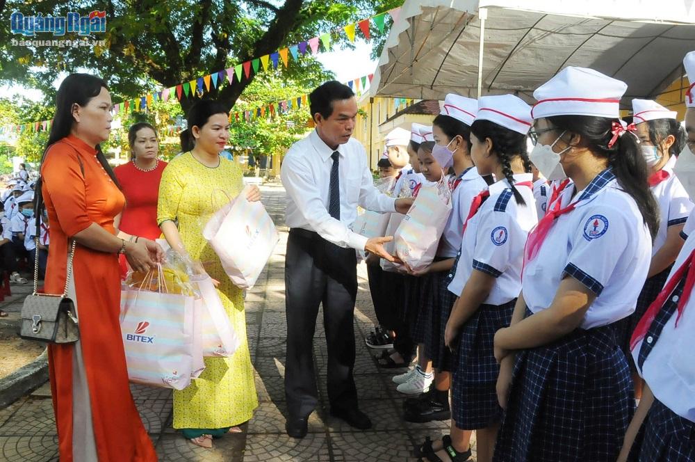 , Trưởng ban Tuyên giáo Đặng Ngọc Dũng trao quà của gia đình Liệt sĩ, Anh hùng LLVT Nguyễn Kim Vang cho học sinh nhà trường. 
