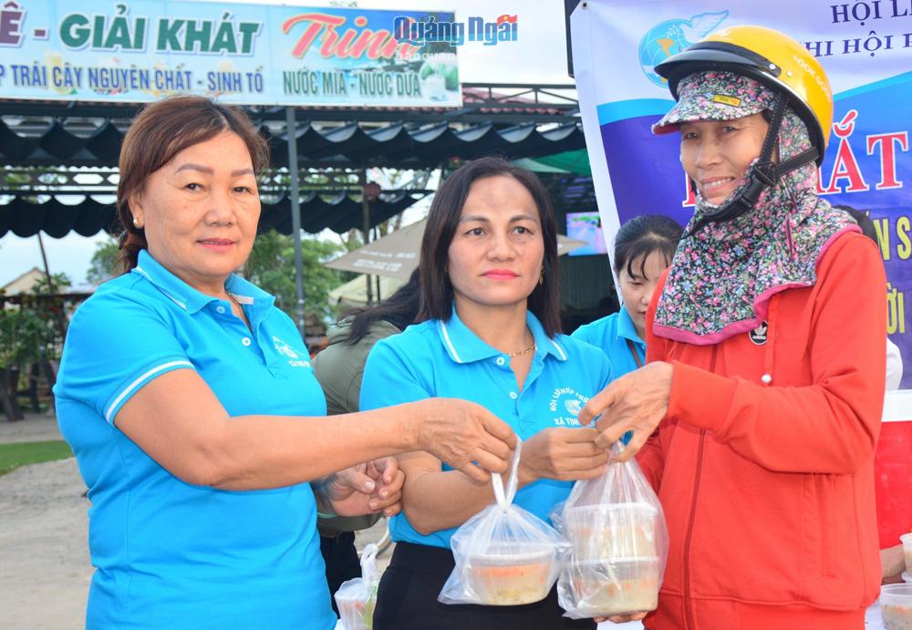 Bà Huỳnh Thị Mai (bên trái) trao “Bữa sáng yêu thương” cho người dân khó khăn ở xã Tịnh Phong (Sơn Tịnh).