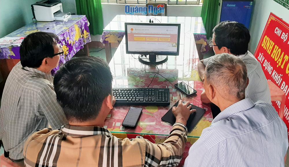 Thành viên Tổ công nghệ số cộng đồng xã Đức Phong (Mộ Đức) hướng dẫn người dân nộp hồ sơ trực tuyến.