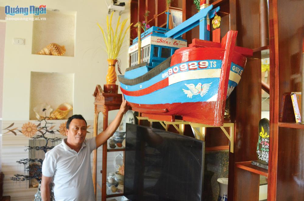 Ngư dân Nguyễn Thanh Nam, ở thôn Châu Thuận Biển, xã Bình Châu (Bình Sơn), bên chiếc tàu gỗ bằng mô hình của gia đình.  Ảnh: Ý THU