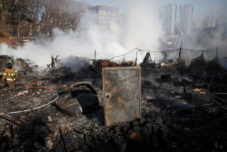 Một cánh cửa còn sót lại giữa đống đổ nát tại hiện trường vụ cháy ở làng Guryong, khu ổ chuột cuối cùng tại quận Gangnam ở Seoul, Hàn Quốc ngày 20-1 - Ảnh: REUTERS