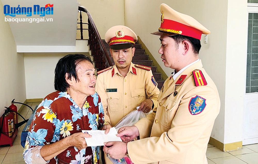 Cán bộ, chiến sĩ Phòng CSGT (Công an tỉnh) tặng quà và giúp đỡ bà Nguyễn Thị Mai (64 tuổi), ở tỉnh Bà Rịa - Vũng Tàu cùng các cháu trở về quê sau khi gặp sự cố trên đường đi.