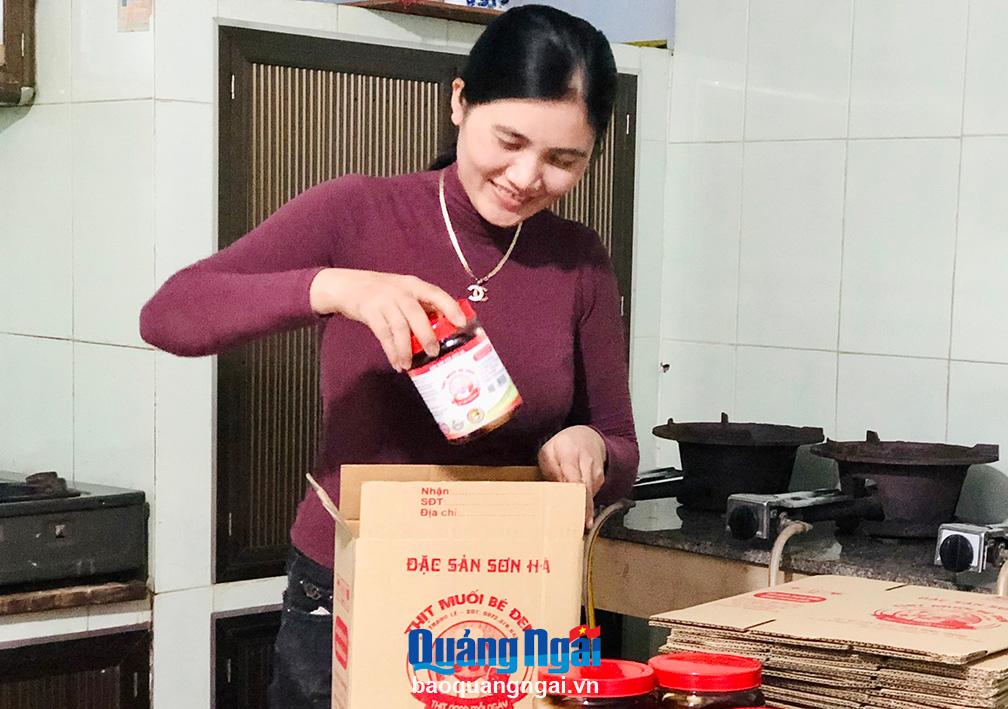 Chị Lê Thị Thùy Trang, ở thị trấn Di Lăng (Sơn Hà), đóng gói thịt heo ngâm mắm để chuyển đi các tỉnh.    Ảnh: H.T