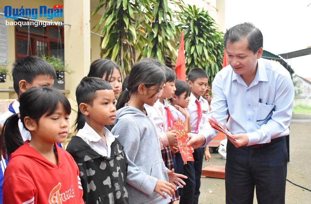 Tổng Biên tập Báo Quảng Ngãi Nguyễn Phú Đức trao quà Tết cho học sinh Trường Tiểu học Nghĩa Thọ.