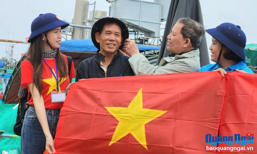 Các thành viên trong Đoàn công tác tặng cờ Tổ quốc cho ngư dân huyện Lý Sơn.