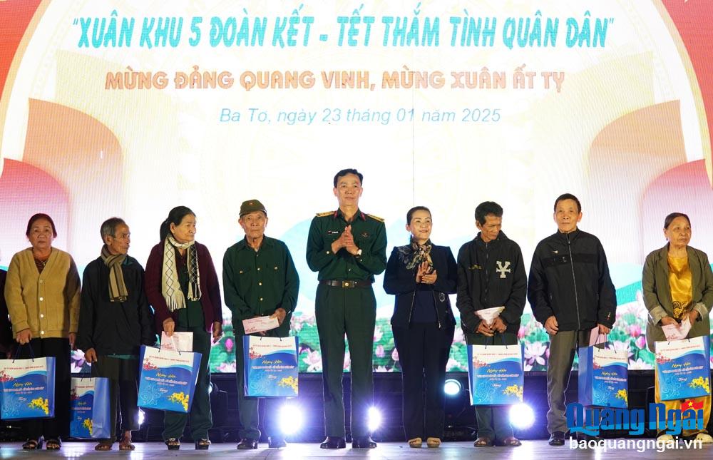 Phó Bí thư Tỉnh ủy Đinh Thị Hồng Minh và Đại tá Vũ Thành Minh - Phó Cục trưởng Cục Dân vận, Tổng Cục chính trị (Bộ Quốc phòng), tặng quà cho người dân huyện Ba Tơ.