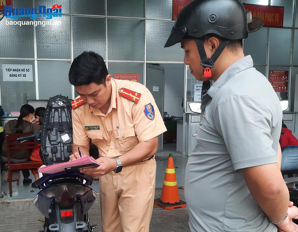 Cán bộ Đội CSGT Công an TP.Quảng Ngãi kiểm tra hồ sơ xe máy để cấp biển số.