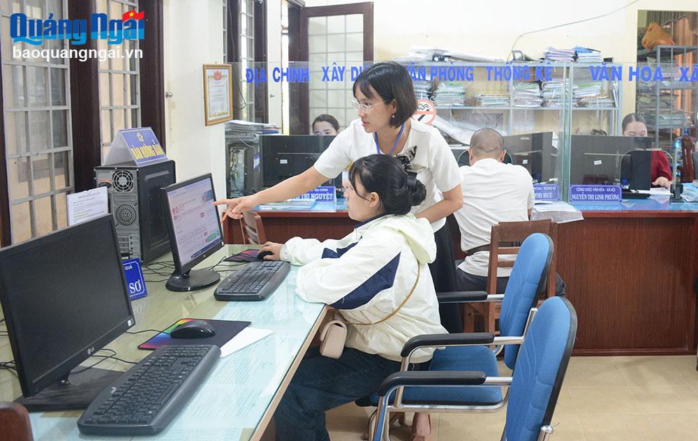 Cán bộ xã Nghĩa Điền (Tư Nghĩa) hướng dẫn người dân tra cứu thủ tục hành chính trên máy tính.