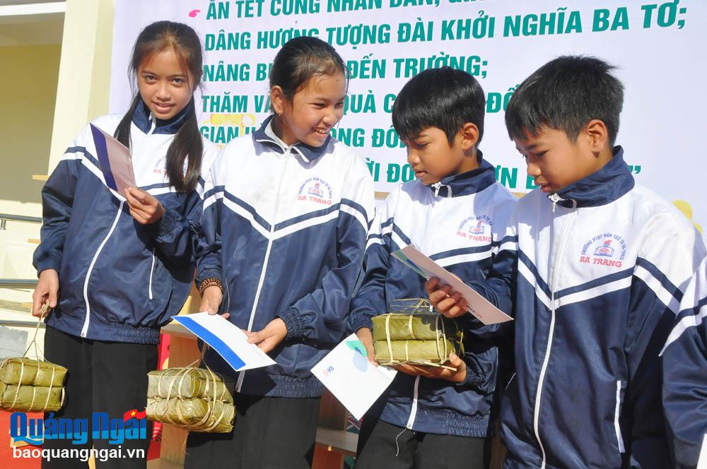 Các em học sinh vui mừng với những món quà Tết được bộ đội trao tặng.