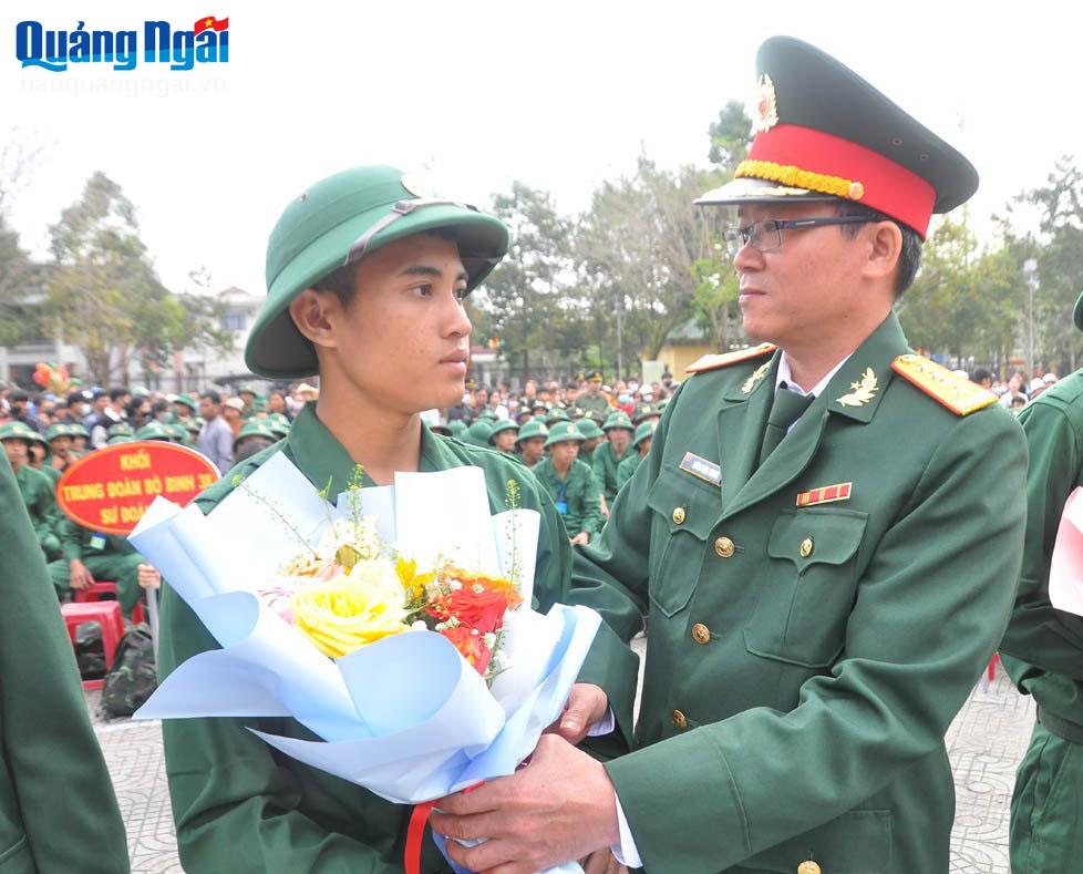 Đại tá Lương Đình Chung - Phó Chính ủy Quân khu 5 tặng hoa động viên thanh niên huyện Ba Tơ lên đường nhập ngũ.