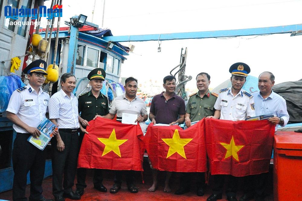 Đại diện Ban Dân vận Tỉnh ủy và Bộ Tư lệnh Vùng Cảnh sát biển 2 tặng quà và cờ Tổ quốc cho chủ tàu cá tại phường Phổ Quang (TX.Đức Phổ).