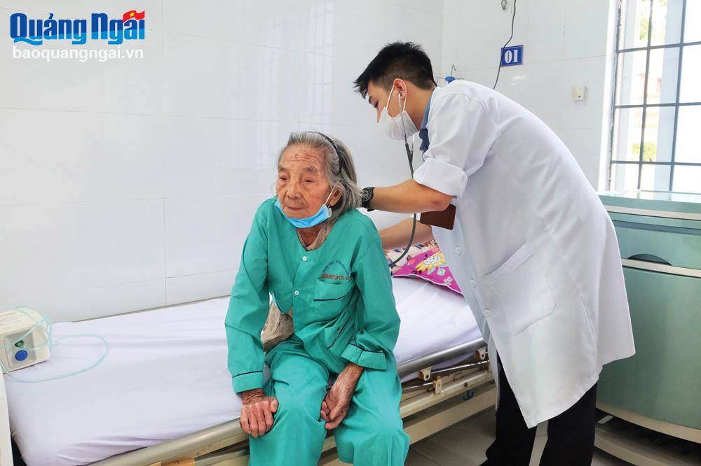 Bác sĩ Nguyễn Anh Khôi khám bệnh cho bệnh nhân lớn tuổi điều trị tại Trung tâm Y tế huyện Bình Sơn.