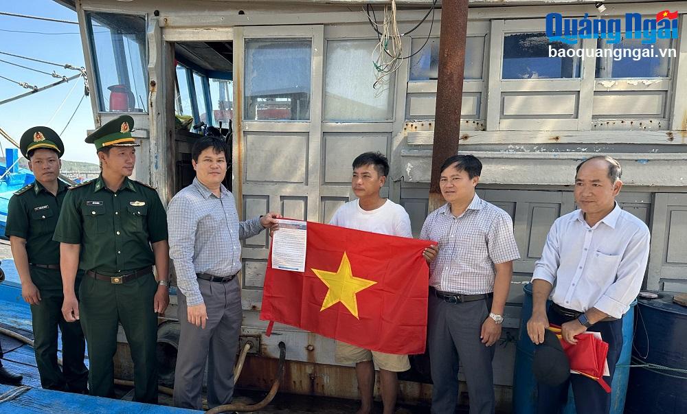 
Phó Chủ tịch UBND tỉnh Trần Phước Hiền trao cờ Tổ quốc và nhắc nhở ngư dân tuân thủ các quy định về khai thác hải sản trên biển. 

