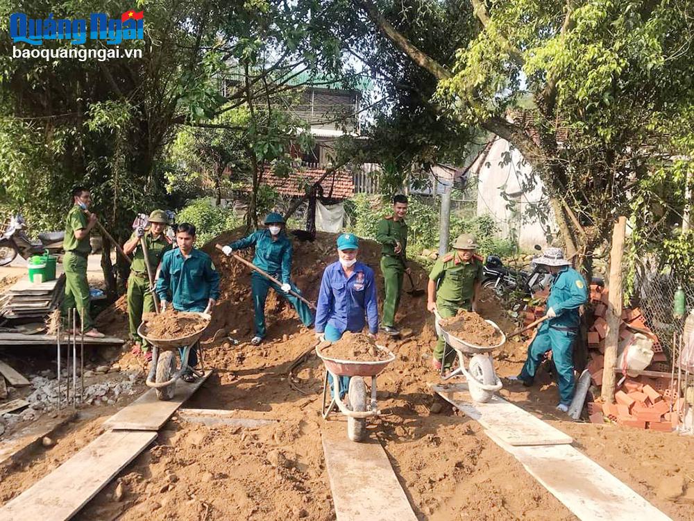 Các lực lượng vũ trang, cùng đoàn viên, thanh niên giúp gia đình ông Đinh Văn Hom, thôn Làng Giữa, xã Long Môn (Minh Long) làm nhà.  