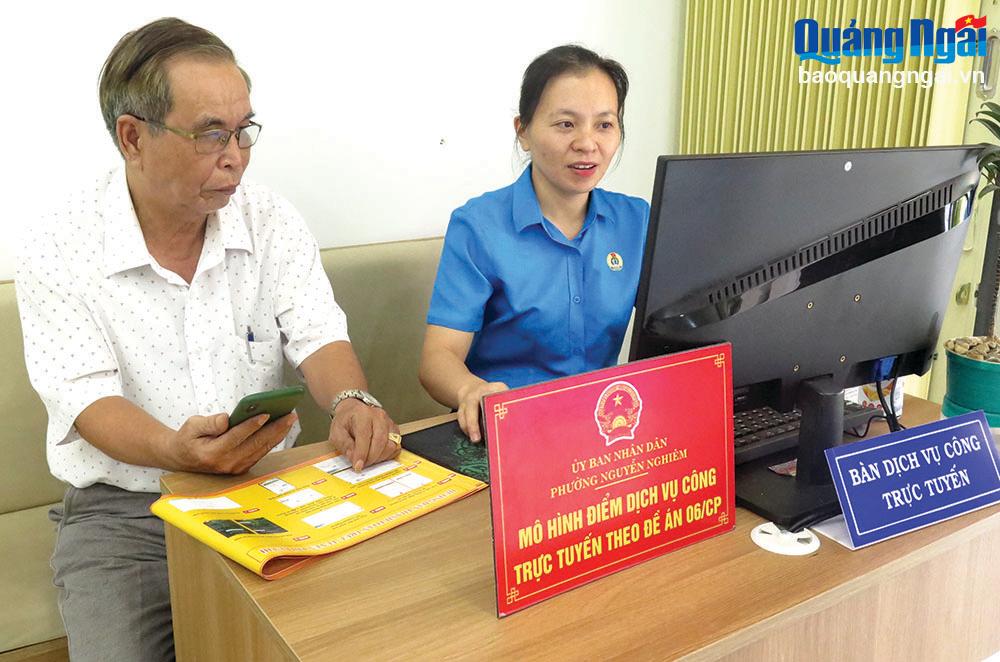 Cán bộ phường Nguyễn Nghiêm (TX.Đức Phổ) hướng dẫn người dân thực hiện dịch vụ công trực tuyến.	