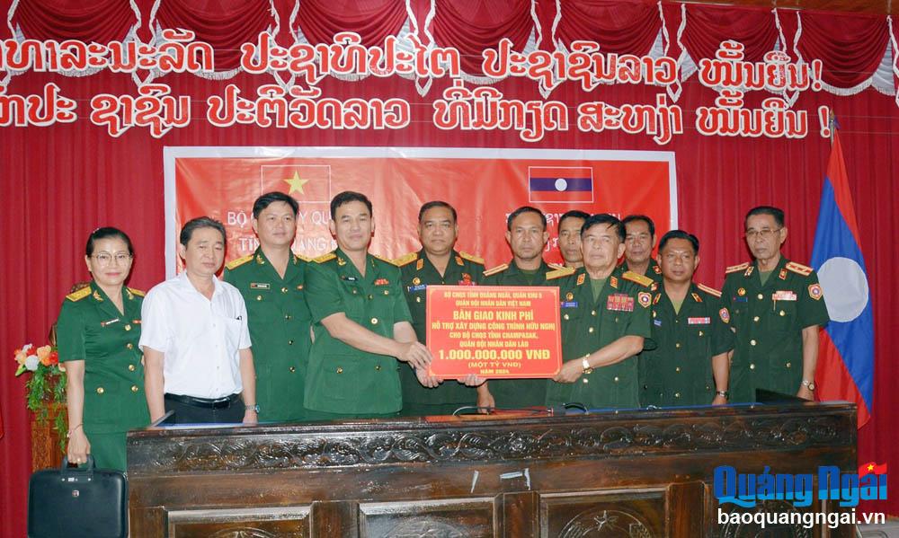 Đại tá Võ Tấn Tài - Chính ủy Bộ CHQS tỉnh trao kinh phí hỗ trợ cho Ban CHQS tỉnh Champasak.
