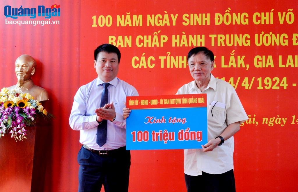 Phó Bí thư Thường trực Tỉnh ủy, Trưởng đoàn ĐBQH tỉnh Đặng Ngọc Huy trao bảng tượng trưng tặng số tiền 100 triệu đồng cho gia đình đồng chí Võ Thành Trung.