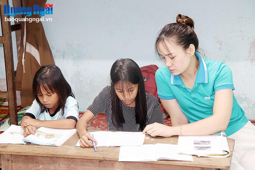 Cô giáo Võ Thị Xuân Thưởng hướng dẫn học sinh làm bài tập trong buổi trực đêm của mình.    